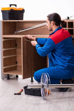 Genç yakışıklı erkek marangoz içeride çalışıyor.