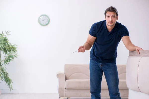 Young male contractor installing furniture at home — Stock Photo, Image