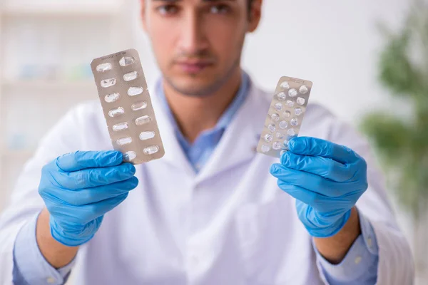 Young male lab assistant in drug synthesis concept — Stock Photo, Image