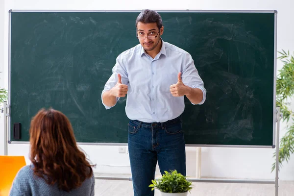 Junge Studentin und männlicher Lehrer im Klassenzimmer — Stockfoto