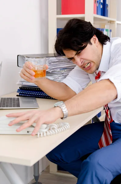 Młody pracownik biznesu pije w biurze — Zdjęcie stockowe