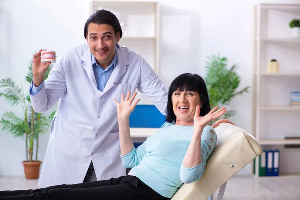 Gammal kvinna besöker ung läkare tandläkare — Stockfoto