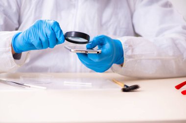 Erkek kriminolog kanıt için laboratuarda çalışıyor.
