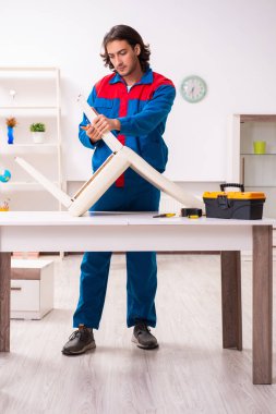 Genç erkek marangoz içeride çalışıyor.