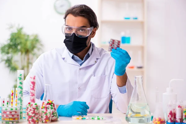 Jonge mannelijke chemicus in drug synthese concept — Stockfoto