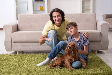Genç baba ve oğlu cocker spaniel köpeğiyle