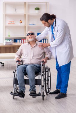 Yaşlı kör adam genç erkek doktoru ziyaret ediyor.