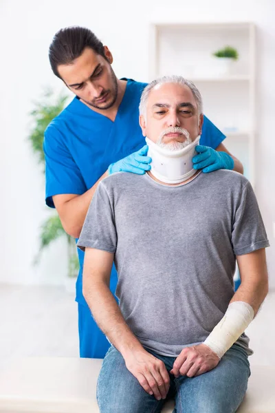 Junger Arzt und alter Patient im Erste-Hilfe-Konzept — Stockfoto