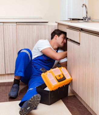 Mutfakta çalışan genç tamirci.