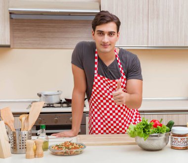Erkek aşçı mutfakta yemek hazırlıyor.