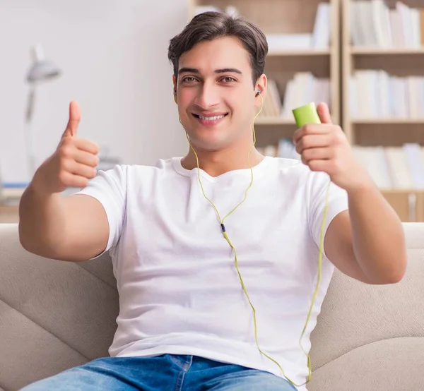 Hombre escuchando música sentado en el sofá —  Fotos de Stock