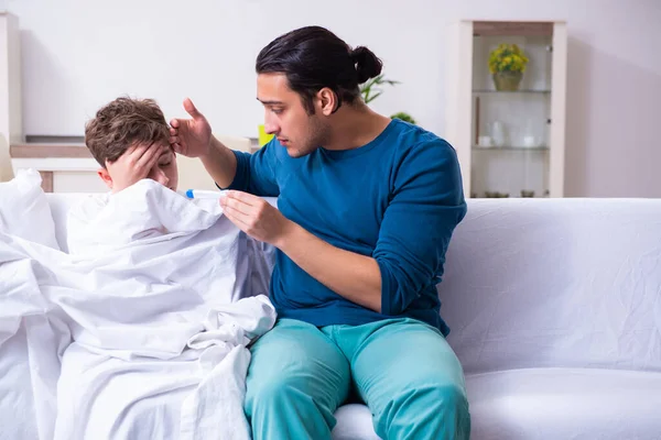 Jovem pai cuidando do filho doente — Fotografia de Stock