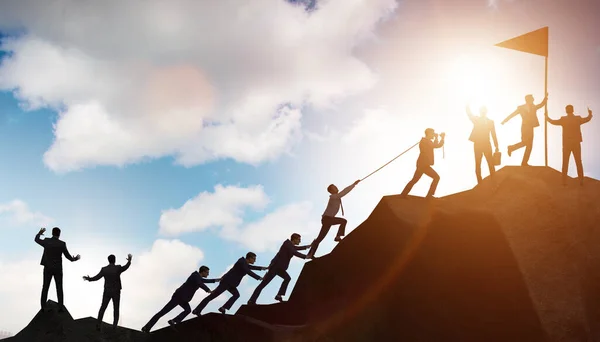 Conceito de trabalho em equipe com equipe de escalada no topo da montanha — Fotografia de Stock