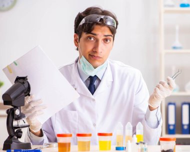 Laboratuvarda çalışan yakışıklı bir kimyager.