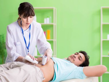 Genç adam ultrason prosedürü için radyolojisti ziyaret ediyor.