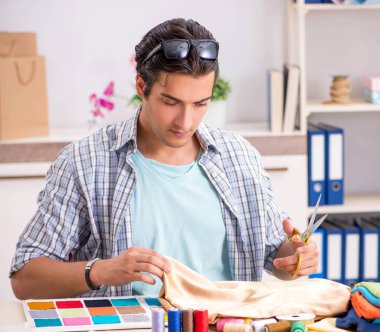 Atölyesinde çalışan yakışıklı bir terzi.