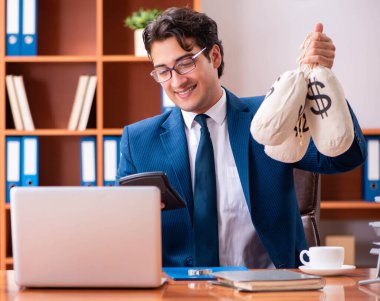 Genç yakışıklı işadamı ofiste çalışıyor.