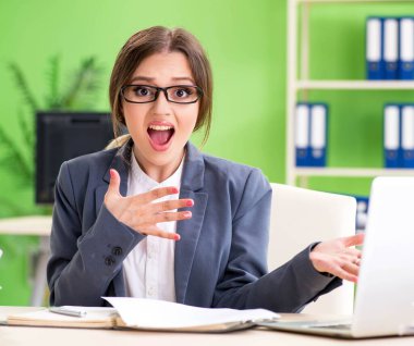 Genç bayan çalışan devam eden evrak işleriyle çok meşgul.