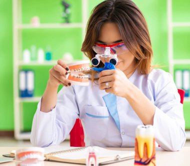 Diş implantı üzerinde çalışan kadın dişçi.