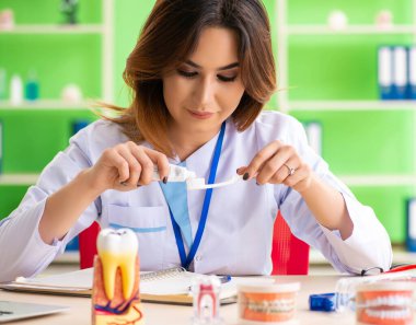 Diş implantı üzerinde çalışan kadın dişçi.