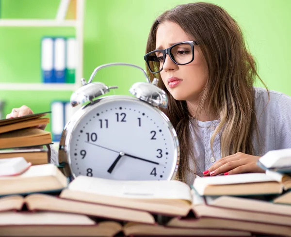 Mladá studentka se připravuje na zkoušky s mnoha knihami v čase — Stock fotografie