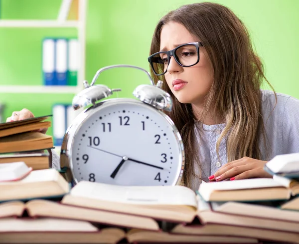 Ung kvinnlig student förbereder sig för tentor med många böcker i tid — Stockfoto