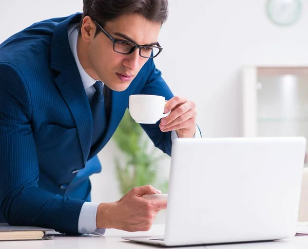 Jonge knappe zakenman die koffie drinkt op kantoor — Stockfoto