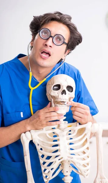 Grappige dokter met skelet in ziekenhuis — Stockfoto