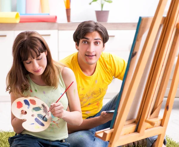 Giovane coppia godendo la pittura a casa — Foto Stock