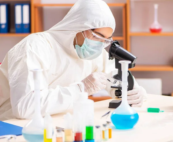 Laboratuvarda çalışan koruyucu elbise giyen genç bir biyokimyacı. — Stok fotoğraf