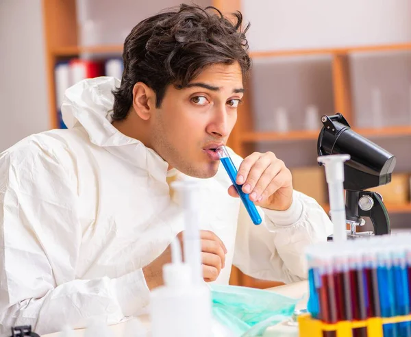 Jonge biochemicus in een beschermend pak in het lab — Stockfoto