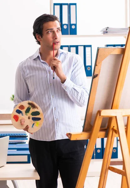 Νέος όμορφος υπάλληλος απολαμβάνει τη ζωγραφική στο γραφείο — Φωτογραφία Αρχείου