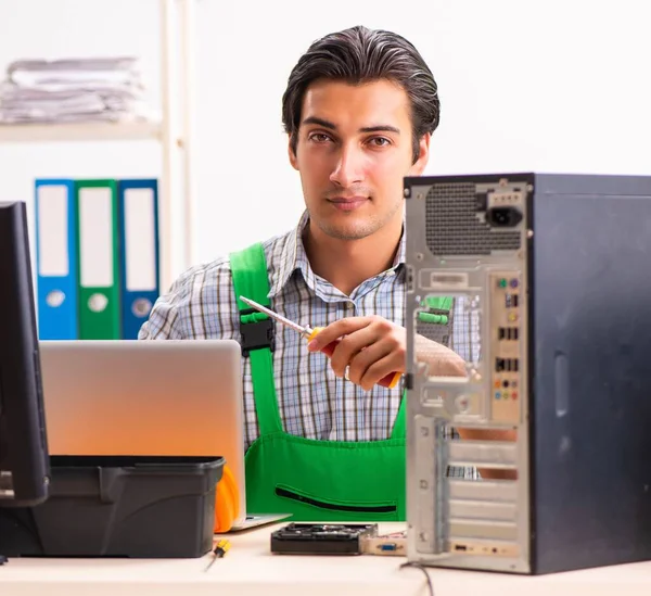 Jonge ingenieur repareert kapotte computer op kantoor — Stockfoto