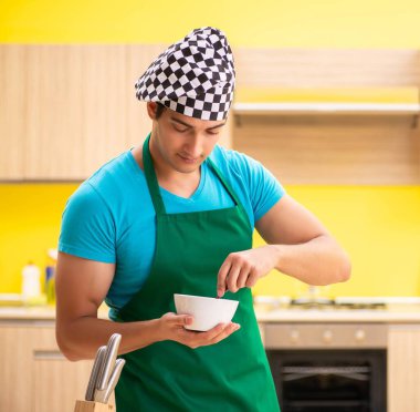 Genç profesyonel aşçı mutfakta hazırlanıyor.