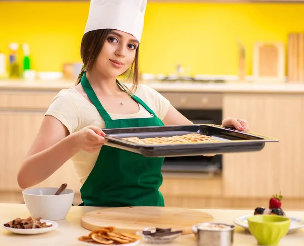 Young cook cooking cakes in the kitchen — Stock Photo, Image