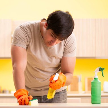 Bekar adam mutfağı temizliyor.