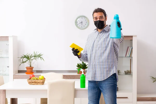 Νεαρός εργολήπτης καθαρίζει το σπίτι με την έννοια coronavirus — Φωτογραφία Αρχείου