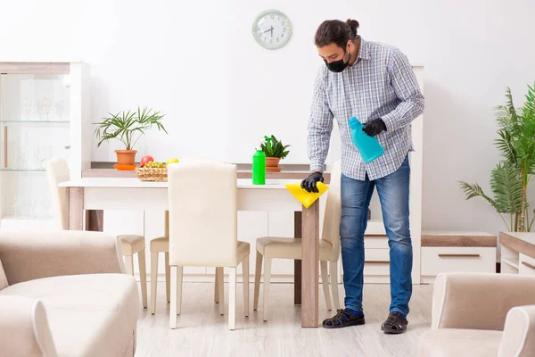 Joven contratista masculino limpiando la casa en concepto de coronavirus —  Fotos de Stock