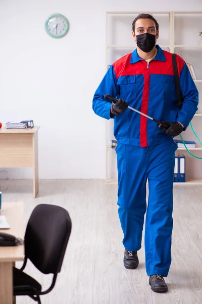 Contratista masculino joven desinfectando oficina — Foto de Stock