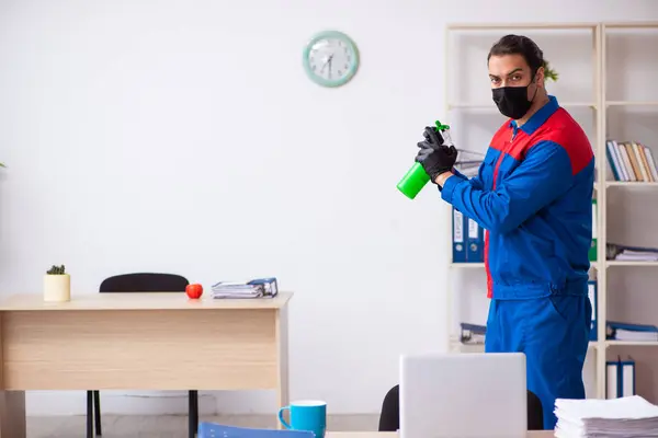 Contratista masculino joven desinfectando oficina — Foto de Stock