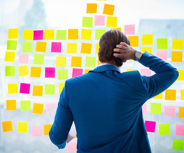 Young handsome employee with many conflicting priorities