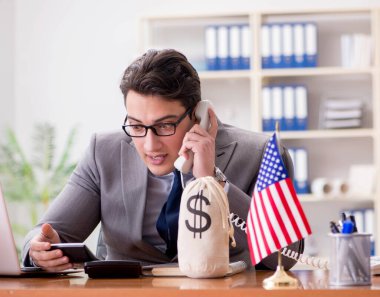 Ofisinde Amerikan bayrağı taşıyan bir iş adamı