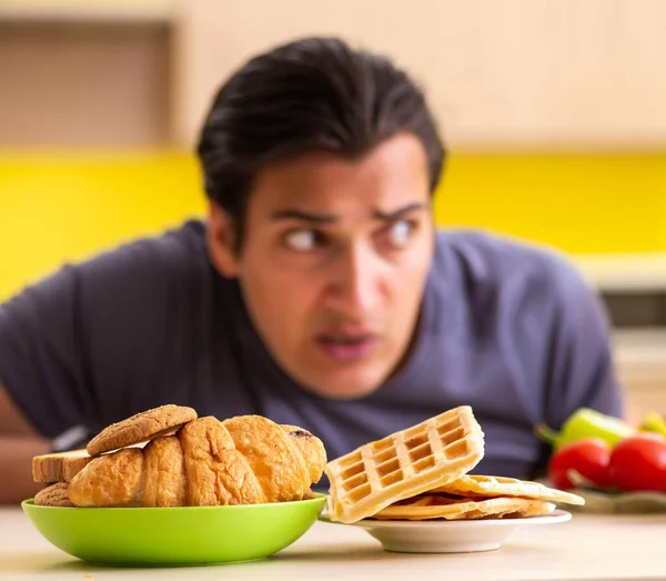 Man having hard choice between healthy and unhealthy food — Stock Photo, Image