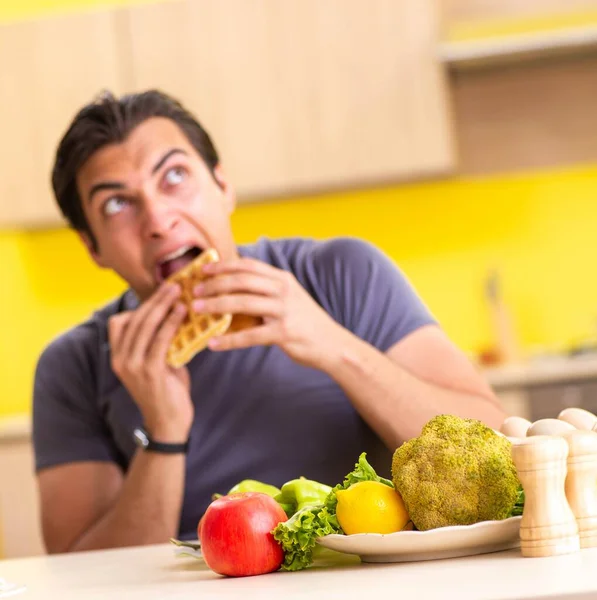 Hombre que tiene difícil elección entre la comida sana y no saludable — Foto de Stock