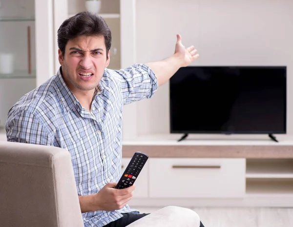 Человек пытается починить сломанный телевизор — стоковое фото