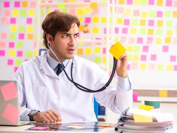 Male doctor with many conflicting prioritites — Stock Photo, Image