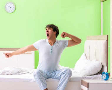 Genç adam sabahın köründe uyanmakta zorlanıyor.