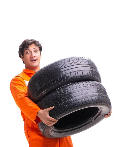 Mladý garážový pracovník s pneumatikou izolovanou na bílém — Stock fotografie