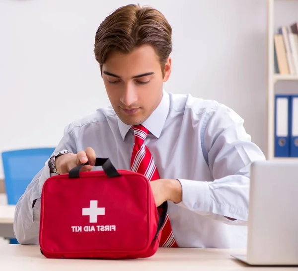 Man with first aid kit in the office — Stock Photo, Image