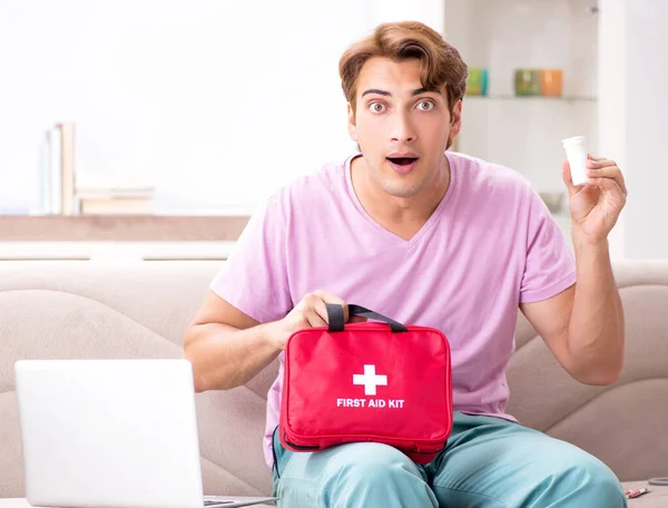 Sick man at home with first aid kit — Stock Photo, Image